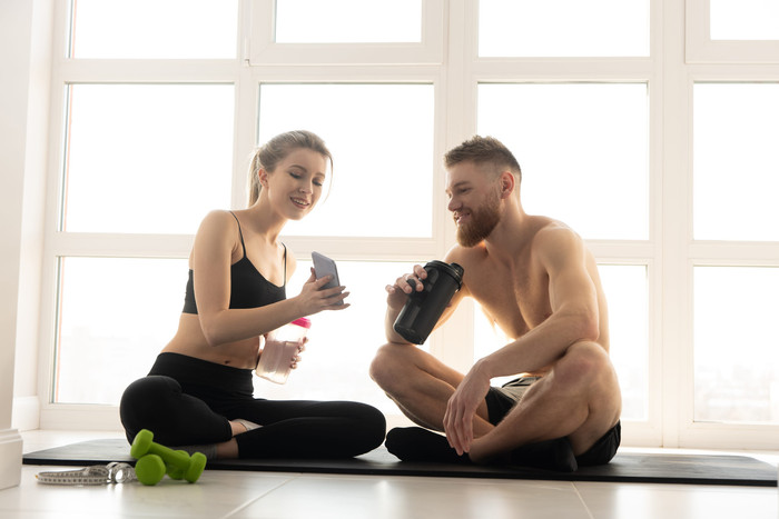 Sportolók mobiltelefonon néznek edzésadatokat a regeneráció és az immunrendszer támogatása kapcsán